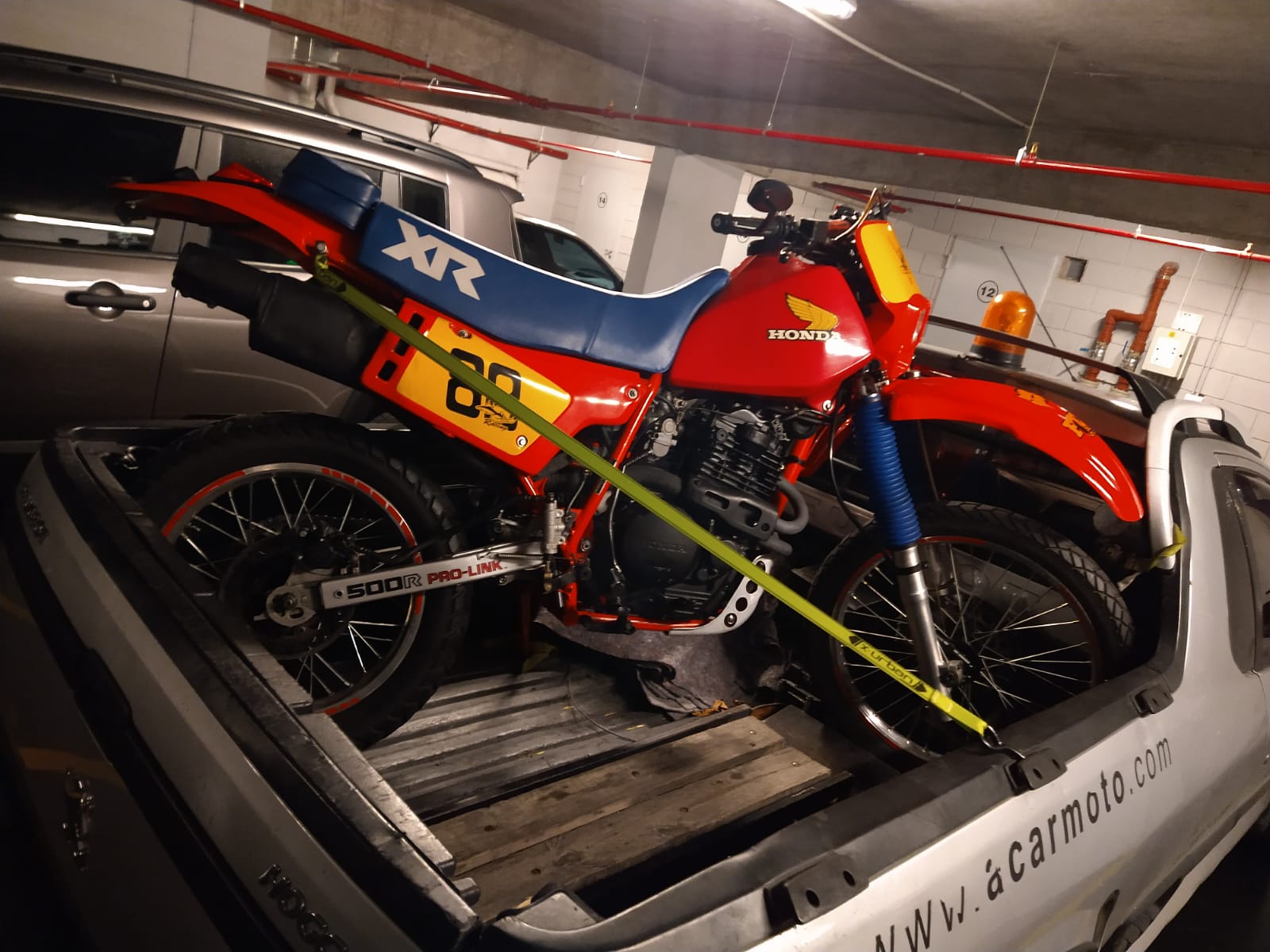 Moto roja asegurada sobre vehículo de Acarmoto